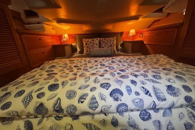 Slide: The Image of Cozy cabin bedroom in 1999 Catalina 470 yacht with seashell-patterned bedding and warm lighting. - 57