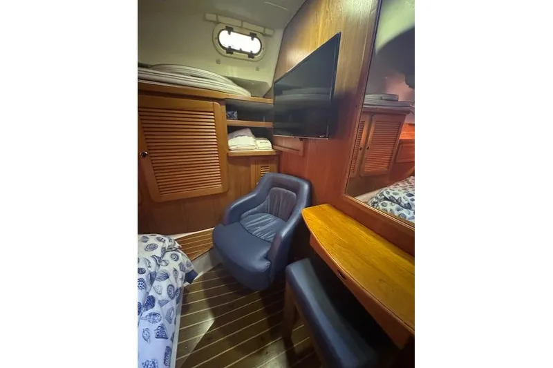Slide: The Image of Cozy cabin interior of 1999 Catalina 470 yacht with wooden furnishings and seating. - 58