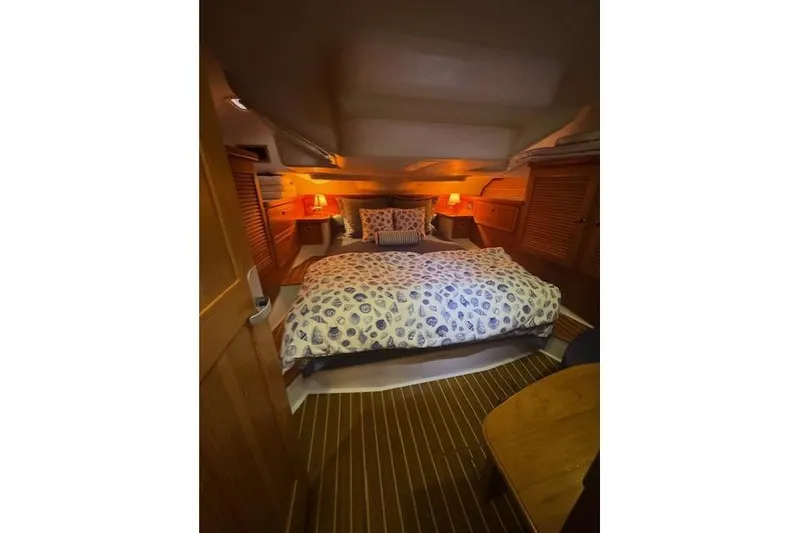 Slide: The Image of Cozy cabin interior of 1999 Catalina 470 sailboat with warm lighting and patterned bedding. - 59