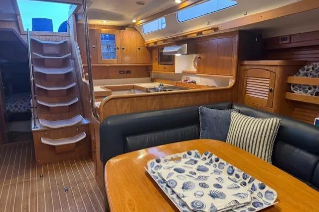 Slide: The Image of Interior of a 1999 Catalina 470 yacht with wooden cabinetry and cozy seating area. - 62