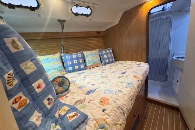 Slide: The Image of Cozy cabin interior of 1999 Catalina 470 sailboat with nautical-themed bedding. - 63