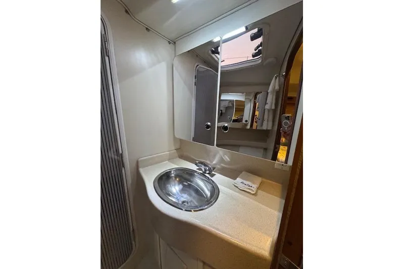 Slide: The Image of Bathroom vanity in a 1999 Catalina 470 yacht, featuring a sink and mirrored cabinet. - 64