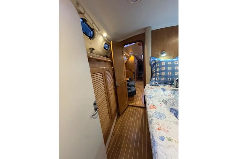 Slide: The Image of Interior of 1999 Catalina 470 yacht with wooden flooring and cozy bedding. - 65
