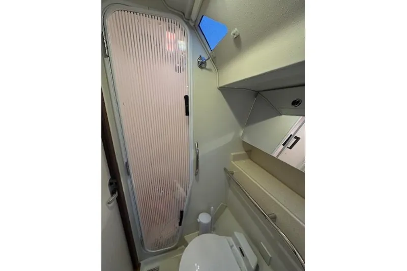 Slide: The Image of Bathroom interior of a 1999 Catalina 470 yacht, featuring a shower and toilet. - 67