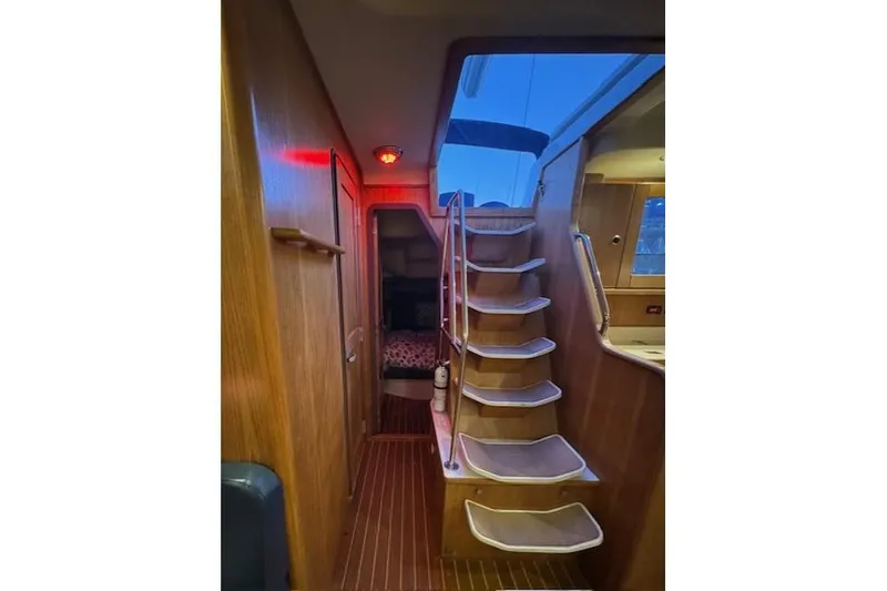 Slide: The Image of Interior of a 1999 Catalina 470 sailboat with wooden stairs and cozy cabin. - 69