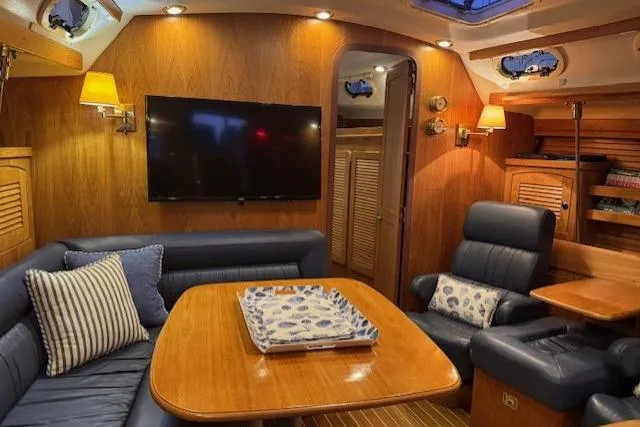 Slide: The Image of Luxurious interior of a 1999 Catalina 470 yacht with plush seating and wooden finishes. - 71
