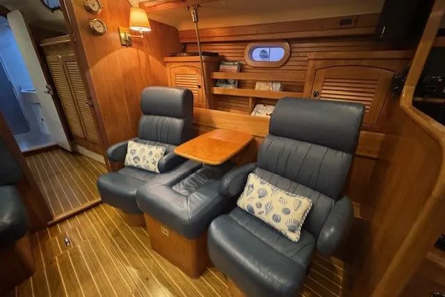 Slide: The Image of Interior of a 1999 Catalina 470 yacht with plush seating and wooden accents. - 72