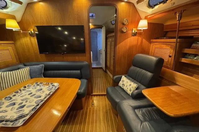 Slide: The Image of Luxurious interior of a 1999 Catalina 470 yacht with wood paneling and comfortable seating. - 73