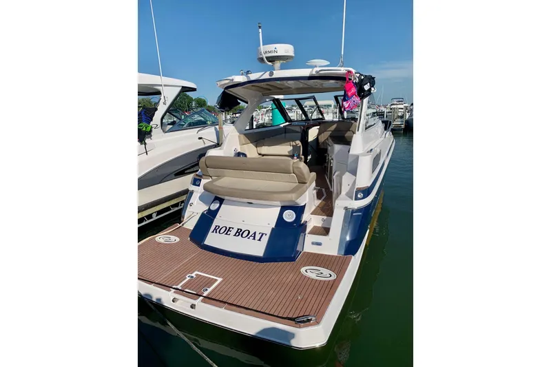 Slide: The Image of 2014 Regal 35 Sport Coupe boat docked, featuring spacious seating and modern design. - 3