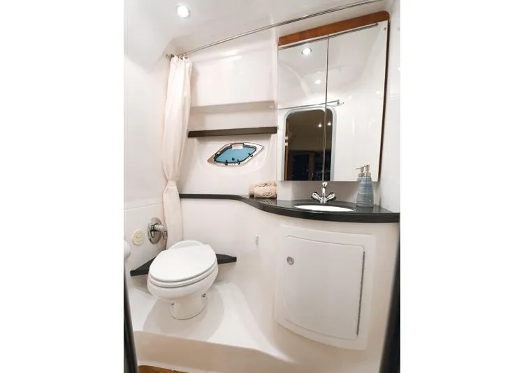 Slide: The Image of Manufacturer Provided Image: 2014 Regal 35 Sport Coupe bathroom with toilet, sink, mirror, and porthole window. - 52