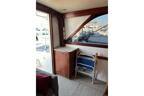 Slide: The Image of 1985 Ocean Yachts 38 Super Sport interior with wooden cabinetry and folding chairs. - 10
