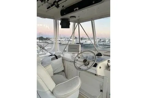 Slide: The Image of 1985 Ocean Yachts 38 Super Sport helm with marina view, featuring classic design and controls. - 3