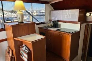Slide: The Image of Interior of 1985 Ocean Yachts 38 Super Sport with wooden cabinetry and marina view. - 9
