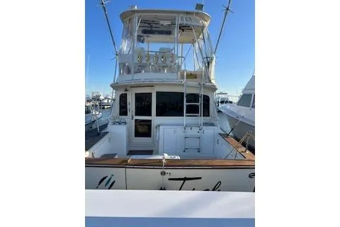 Slide: The Image of 1985 Ocean Yachts 38 Super Sport docked, showcasing rear view and upper deck. - 2