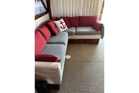 Slide: The Image of 1985 Ocean Yachts 38 Super Sport interior with red and gray seating, anchor-themed pillow. - 8