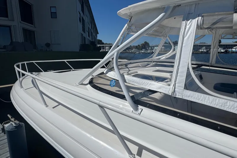 Slide: The Image of 2012 Intrepid 390 Sport Yacht with white canopy and railing, docked near waterfront buildings. - 18