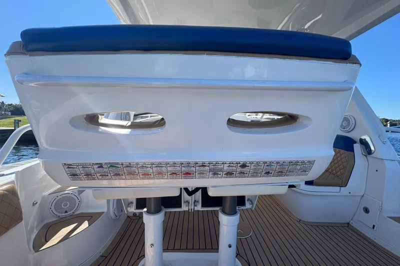 Slide: The Image of 2012 Intrepid 390 Sport Yacht interior with seating and control panel, docked on a sunny day. - 22