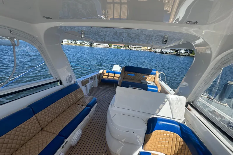 Slide: The Image of Luxurious 2012 Intrepid 390 Sport Yacht interior with blue and tan seating on the water. - 52