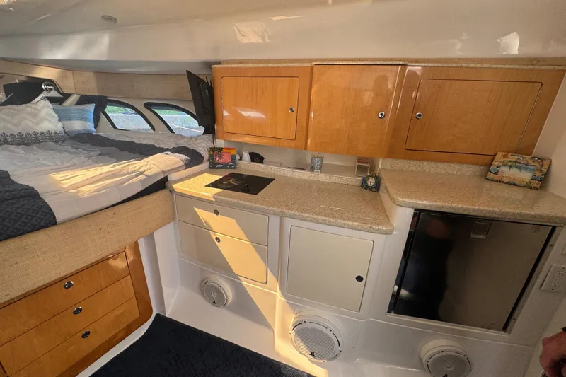 Slide: The Image of Interior of 2012 Intrepid 390 Sport Yacht with bed, cabinets, and kitchenette. - 55