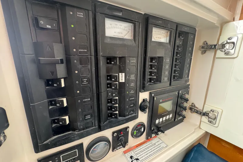 Slide: The Image of Electrical control panel of a 2012 Intrepid 390 Sport Yacht, featuring various switches and gauges. - 61
