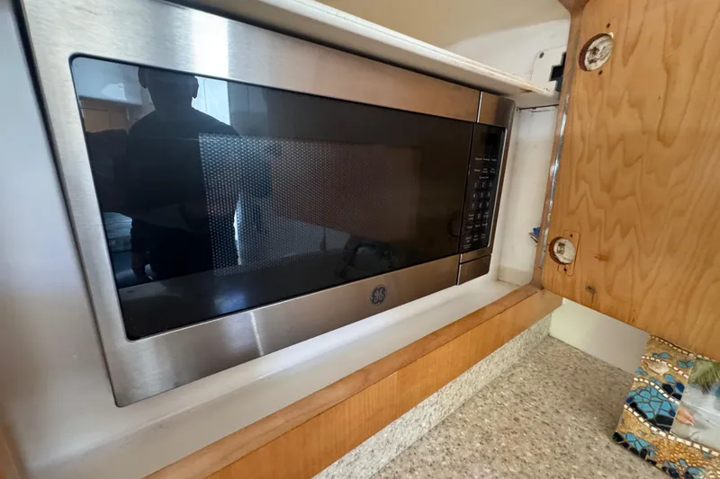 Slide: The Image of Built-in GE microwave in 2012 Intrepid 390 Sport Yacht kitchen area. - 69