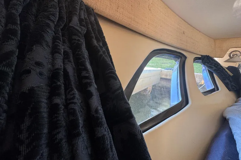 Slide: The Image of Interior view of 2012 Intrepid 390 Sport Yacht with window and dark curtains. - 76