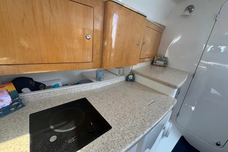 Slide: The Image of Interior of 2012 Intrepid 390 Sport Yacht with sleek countertops and wooden cabinets. - 77