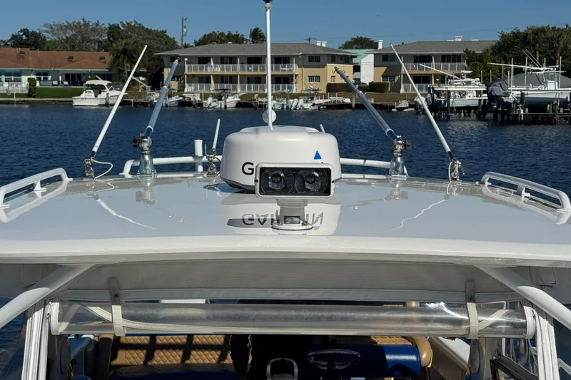 Slide: The Image of 2012 Intrepid 390 Sport Yacht with radar, docked near waterfront homes. - 86