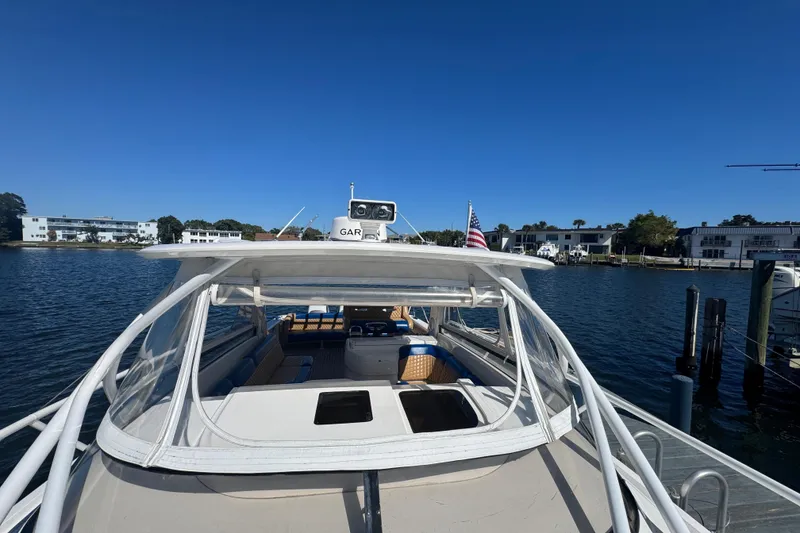 Slide: The Image of 2012 Intrepid 390 Sport Yacht docked, featuring spacious deck and clear canopy. - 87