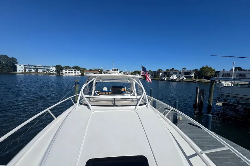 Slide: The Image of 2012 Intrepid 390 Sport Yacht docked at marina, clear blue sky, American flag displayed. - 9