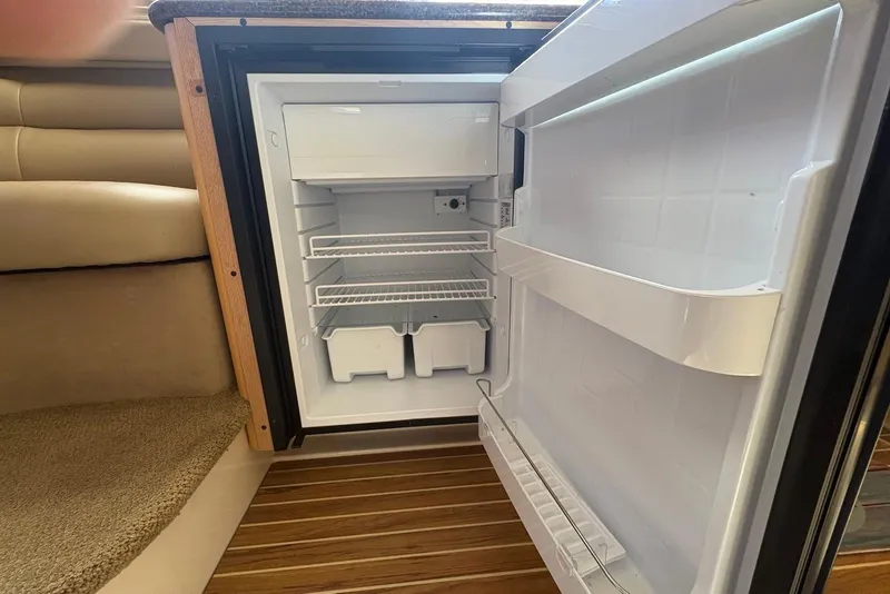Slide: The Image of Open refrigerator inside 2001 Bayliner 3488 Command Bridge Motoryacht, showcasing interior shelves and compartments. - 21