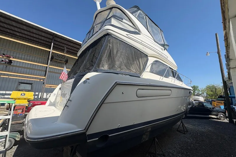 Slide: The Image of 2001 Bayliner 3488 Command Bridge Motoryacht in storage, side view with American flag. - 4