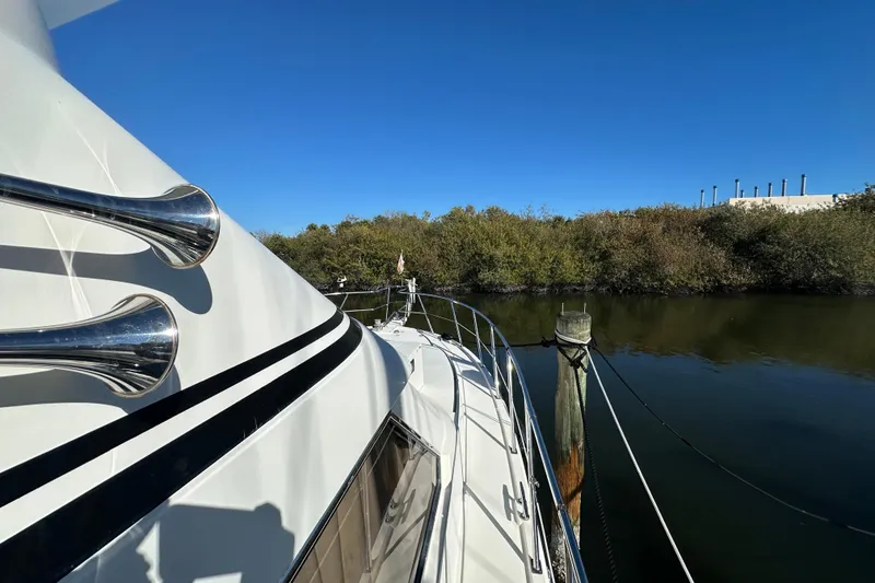 Slide: The Image of Novatec Islander 55 yacht, 2006 model, docked by a serene waterway. - 10
