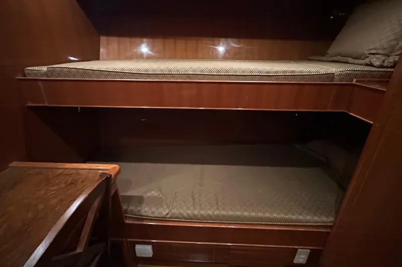 Slide: The Image of Bunk beds in 2006 Novatec Islander 55 yacht cabin, featuring wooden interior and cozy bedding. - 88