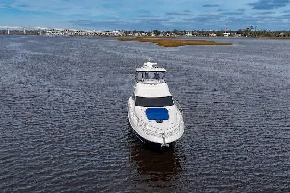 Slide: The Image of 2006 Sea Ray 580 Sedan Bridge yacht on open water, under a partly cloudy sky. - 13