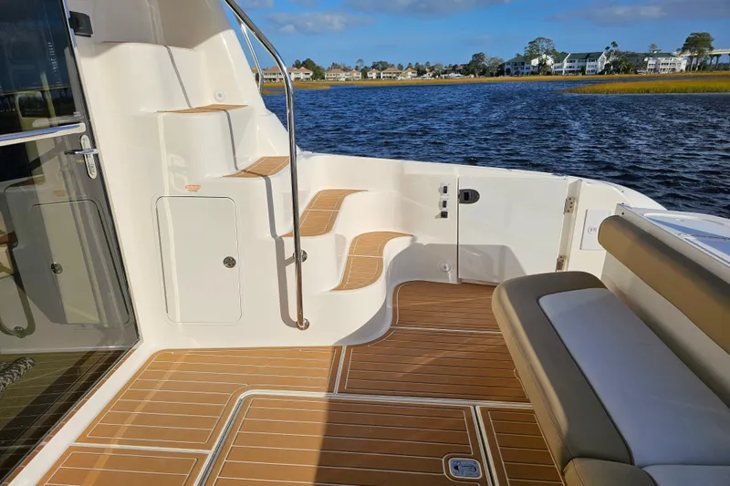 Slide: The Image of 2006 Sea Ray 580 Sedan Bridge yacht deck with elegant wood finish and scenic water view. - 19