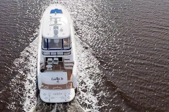 Slide: The Image of 2006 Sea Ray 580 Sedan Bridge yacht cruising on open water, aerial view. - 2