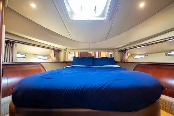 Slide: The Image of Luxurious 2006 Sea Ray 580 Sedan Bridge yacht bedroom with skylight and blue bedding. - 35