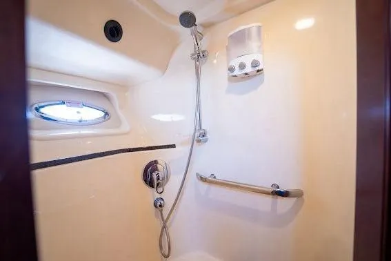 Slide: The Image of Shower area in 2006 Sea Ray 580 Sedan Bridge yacht, featuring modern fixtures and porthole window. - 38