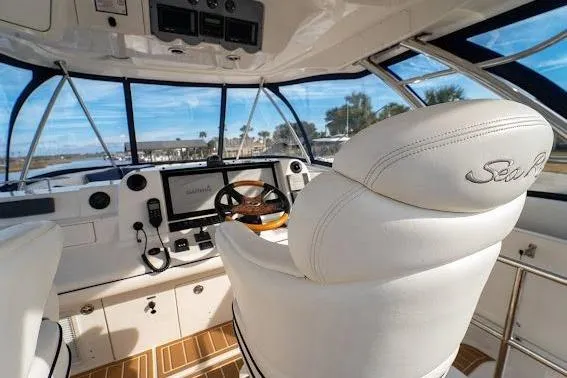 Slide: The Image of 2006 Sea Ray 580 Sedan Bridge helm with luxurious white seating and modern navigation equipment. - 55
