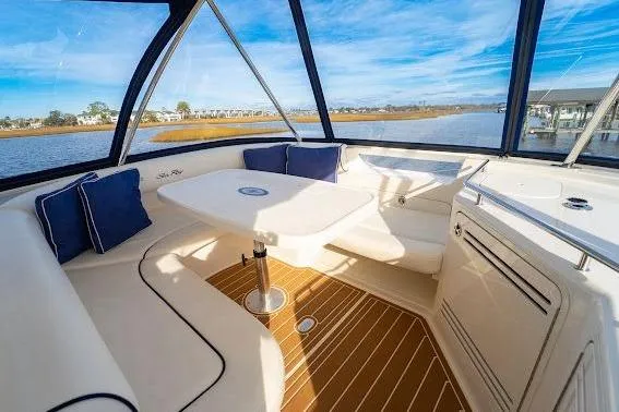 Slide: The Image of 2006 Sea Ray 580 Sedan Bridge interior with seating and table, overlooking serene water views. - 57