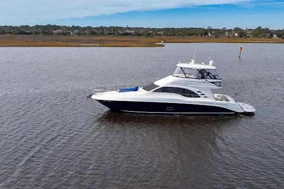 Slide: The Image of 2006 Sea Ray 580 Sedan Bridge yacht on calm water, scenic background. - 8