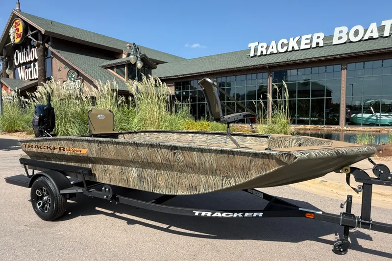 Slide: The Image of 2026 Tracker Grizzly 1756 T Marsh boat displayed outside Tracker Boats store. - 7