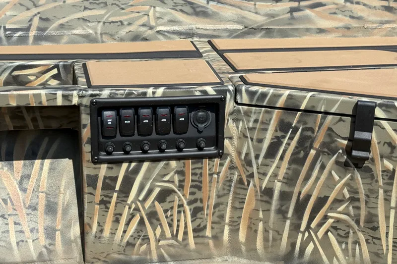 Slide: The Image of 2026 Tracker Grizzly 1756 T Marsh boat console with camouflage design and control panel. - 4