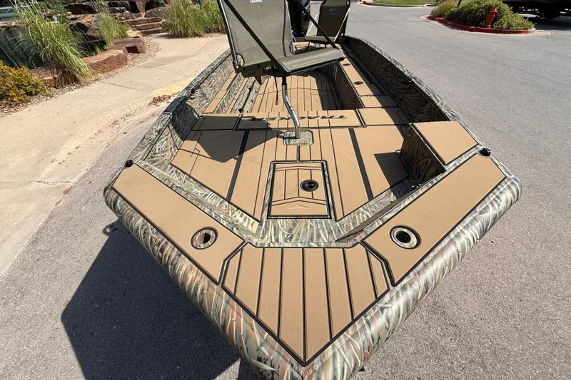 Slide: The Image of 2026 Tracker Grizzly 1756 T Marsh boat with camo design on a street. - 3