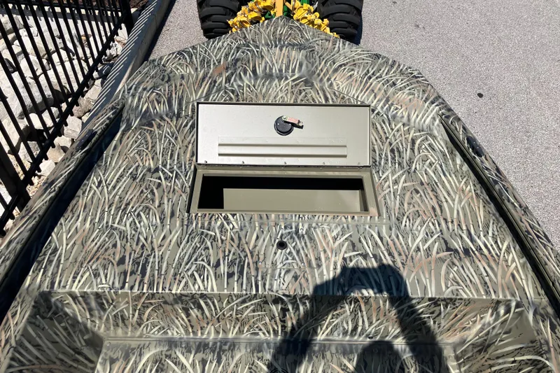 Slide: The Image of 2026 Tracker Grizzly 1648 Utility boat with camouflage pattern and storage compartment. - 2