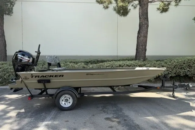 The Image of 2026 Tracker Grizzly 1654 T Sportsman boat on trailer, parked outdoors. - 0