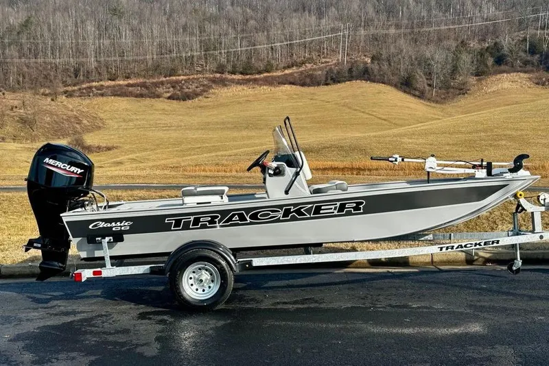 Slide: The Image of 2026 Tracker Bass Tracker Classic CC boat on trailer, scenic countryside background. - 2