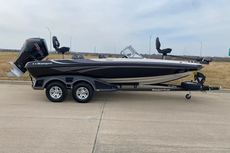 Slide: The Image of 2026 Ranger 212LS boat on trailer, black and white design, parked on concrete. - 4