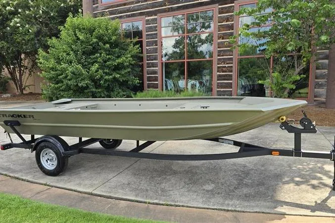 Slide: The Image of 2026 Tracker Grizzly 1754 Utility boat on trailer, parked outdoors near a building. - 3